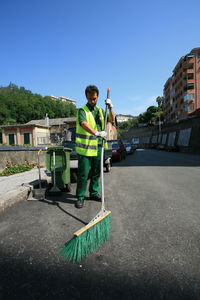 Man standing with umbrella against clear sky