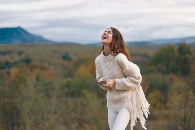 Young woman standing against mountain