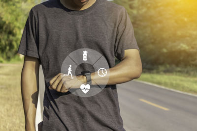 Midsection of man holding camera while standing outdoors