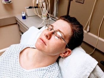 High angle view of woman sleeping on bed in hospital ward