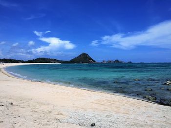 Scenic view of beach against blue sky