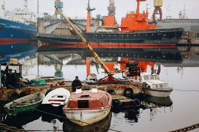 Boats moored at harbor against sky