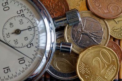 High angle view of clock and coins