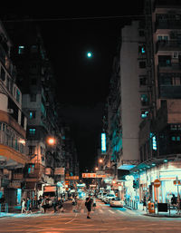 View of city street and buildings at night