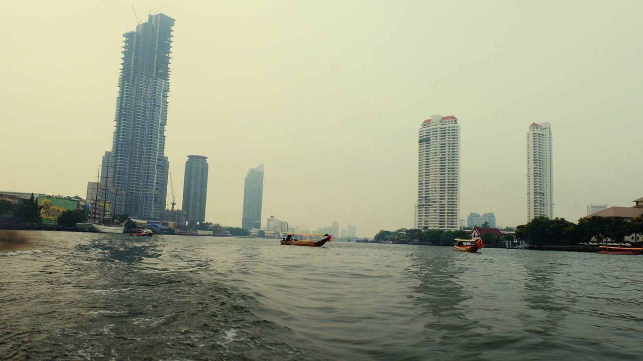 building exterior, built structure, architecture, waterfront, water, city, office building exterior, skyscraper, sky, building, tall - high, nautical vessel, transportation, nature, tower, no people, mode of transportation, clear sky, urban skyline, outdoors, cityscape, financial district