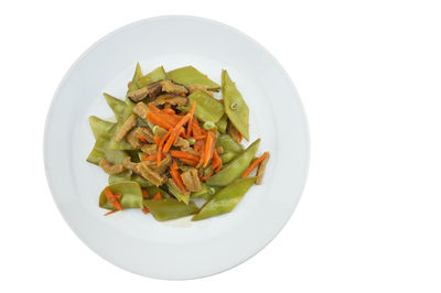 Directly above shot of chopped vegetables in plate against white background