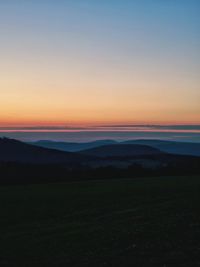 Scenic view of field against clear sky during sunset
