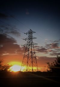 Silhouette electricity pylon on field against sky during sunset