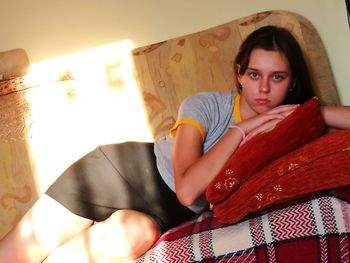 Portrait of woman sitting on sofa at home