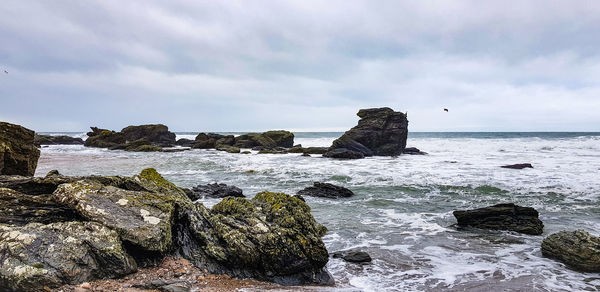 Rocks on beach against sky