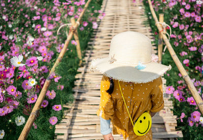 Japan childen stand on the wooden bridge in the bloom garden violet flower