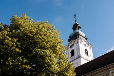 Low angle view of trees and building against sky