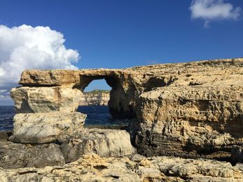 Rock formations on land against blue sky