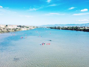 People on beach against blue sky