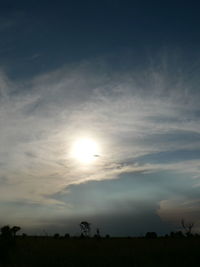 Scenic view of silhouette field against sky at sunset