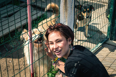 Dog at the shelter.  lonely dogs in cage with cheerful woman volunteer