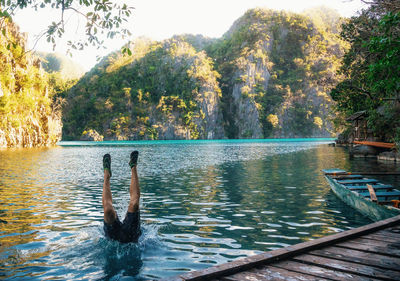 Man swimming in lake by trees