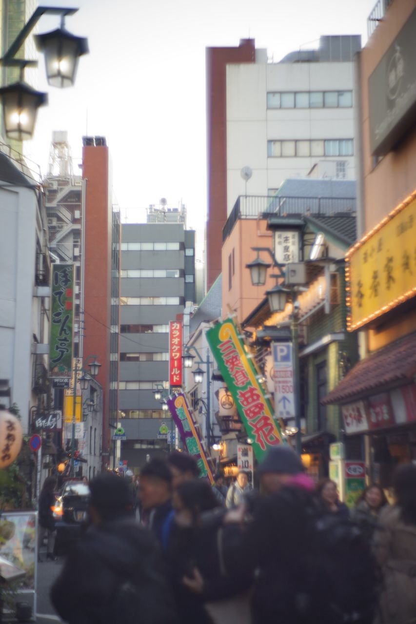 building exterior, architecture, built structure, city, street, city life, city street, building, large group of people, office building, sky, skyscraper, incidental people, road, transportation, outdoors, men, person, car