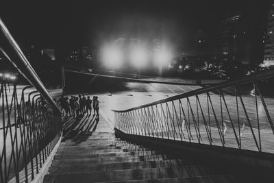 Bridge over illuminated street in city at night