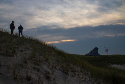 People on field against sky during sunset