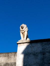 Low angle view of statue against clear blue sky