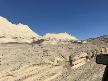 Scenic view of desert against clear blue sky