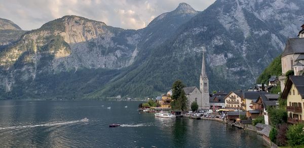 Panoramic view of lake and buildings against mountains