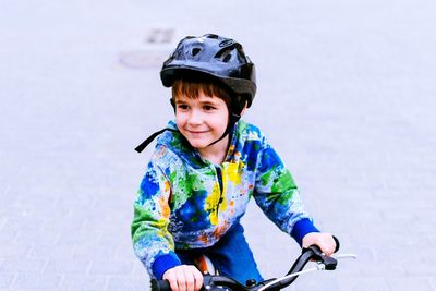 Smiling boy on bicycle looking away
