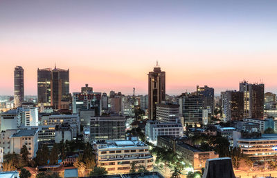 Aerial view of buildings in city during sunset