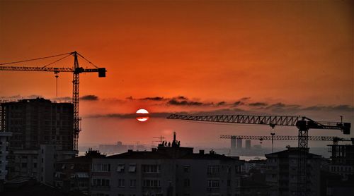 Silhouette buildings against sky during sunset