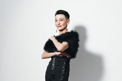 Portrait of young woman standing against white background