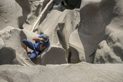 High angle view of people sitting on rock