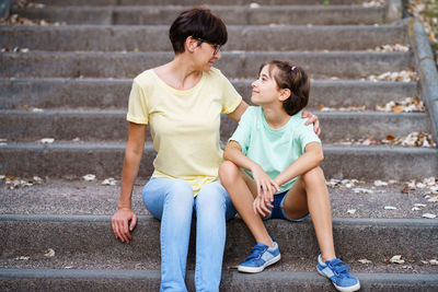 High angle view of friends sitting on staircase