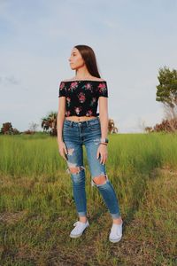 Full length of young woman standing on field