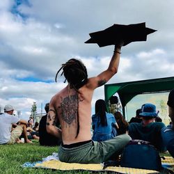 People sitting at music concert against sky