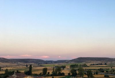 Scenic view of field against clear sky during sunset