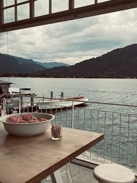 Chairs and table by sea against sky