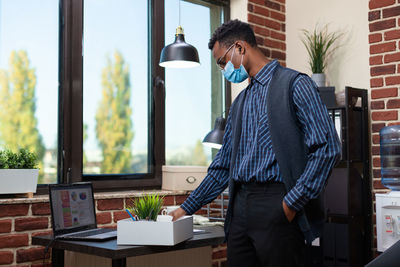 Businessman with hand in pocket standing in office