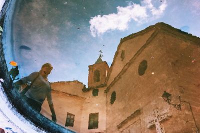 Reflection of woman and cathedral seen in water