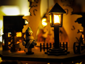 Close-up of illuminated lamp on table