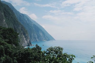 Scenic view of sea and mountains against sky