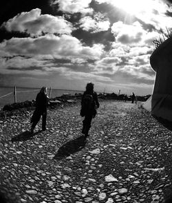 Man standing on beach against cloudy sky