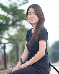 Portrait of smiling young woman sitting outdoors