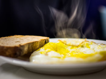 Close-up of omelet with bread in plate on table