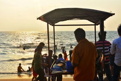 Rear view of people sitting on beach