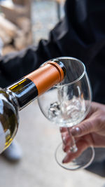 The host pours white wine into the guest's glass
