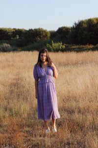 Portrait of a smiling young woman standing on field