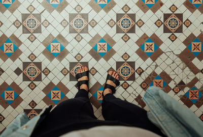 Low section of woman standing on tiled floor