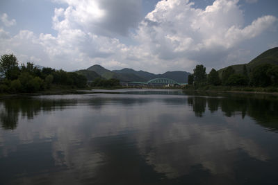 Scenic view of lake by trees against sky