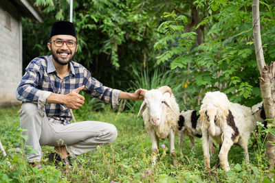 Portrait of man with goat on field